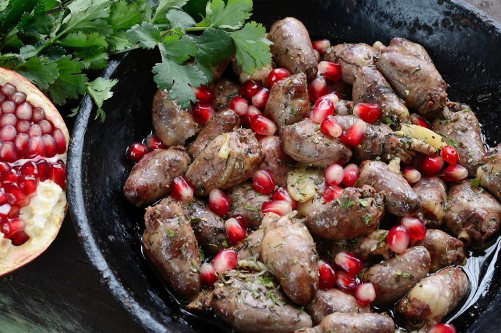 Cooked organ meats with pomegranate seeds and herbs