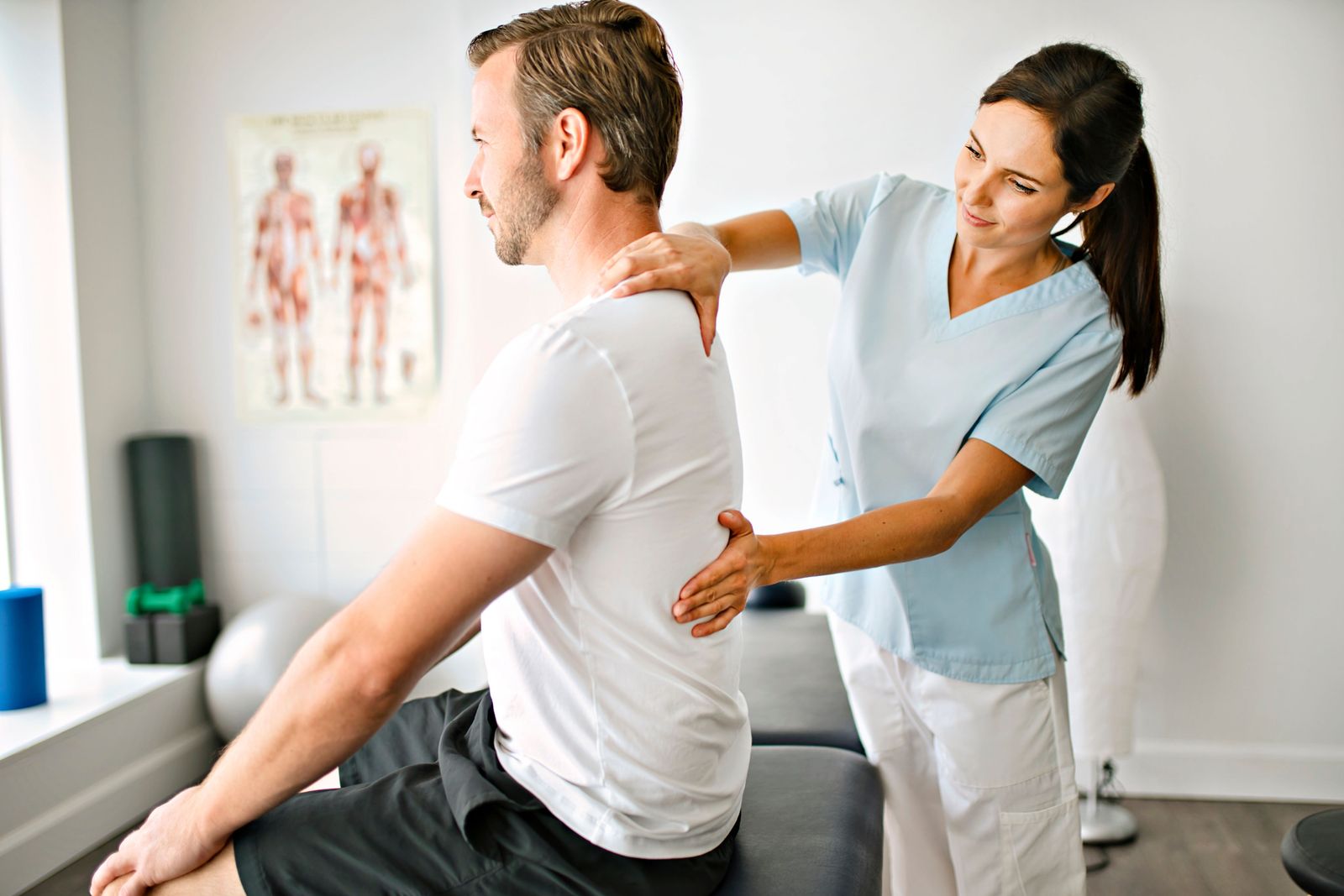 A healthcare professional at Balance Wellspace providing a physical assessment and mobility support to a patient.